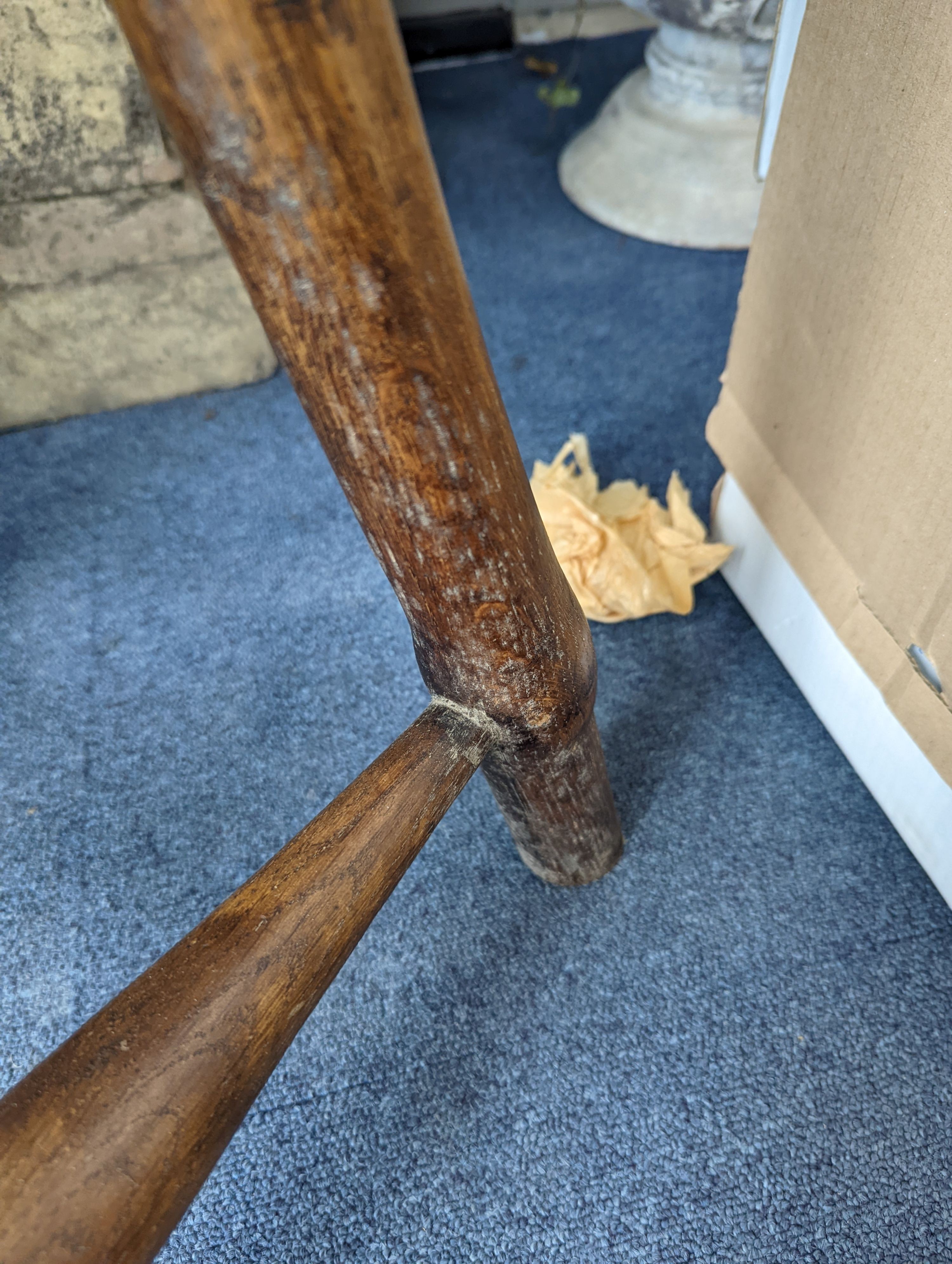 A circular burr elm and ash primitive cricket table with T shaped stretcher, diameter 44cm, height 61cm